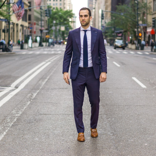 Hombre con traje azul y zapatos marrones